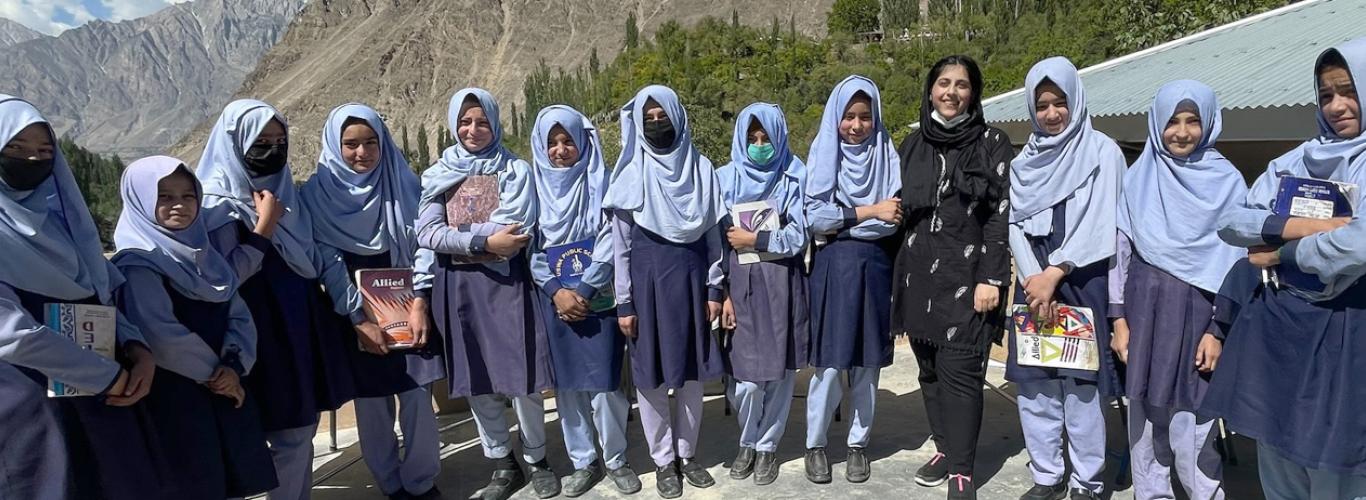 Girls in uniform sitting with a member of the LCSS team 